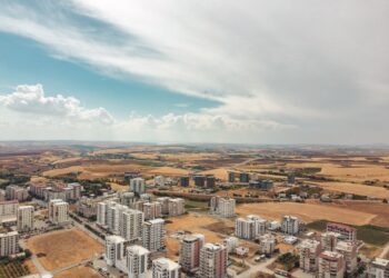 Açık havada, kuru bir coğrafyada yer alan modern toplu konut binaları.