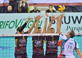 File önünde ellerini havaya kaldırarak blok yapan voleybolcular.