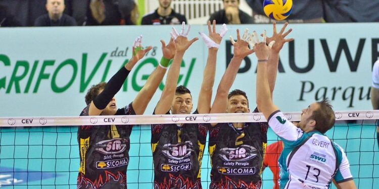 File önünde ellerini havaya kaldırarak blok yapan voleybolcular.