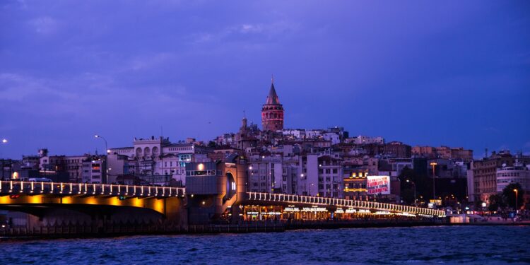 Akşam saatlerinde İstanbul Boğazı ve tarihi Galata Kulesi manzarası.