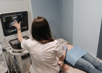 Doktor hastaya ultrason cihazı ile inceleme yapıyor ve ekrandakileri gösteriyor.