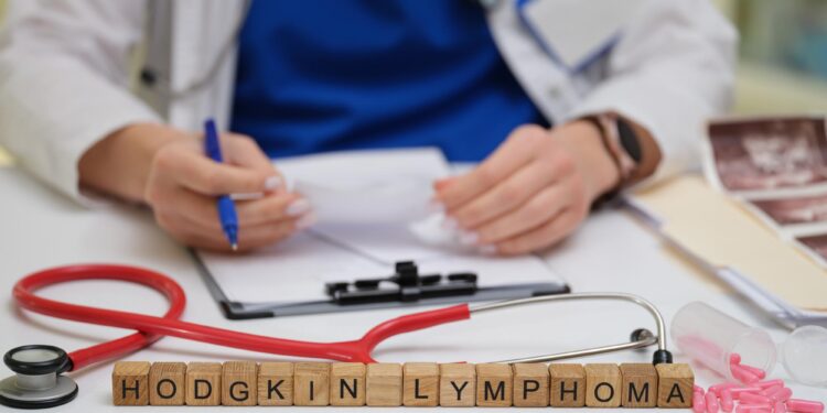 Masada stetoskop ve reçete bulunan doktorun önündeki ahşap harflerle Hodgkin Lymphoma yazıyor.