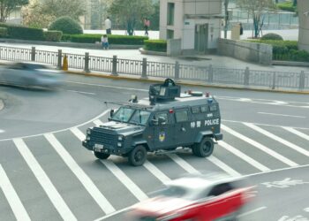 Şehir merkezinde kavşaktan geçen gri renkli zırhlı polis aracı.