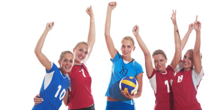 Beyaz arka planda zaferlerini kutlayan kadın voleybolcular.