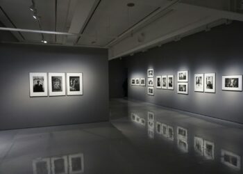Gri tonlu duvarları olan sergi salonunda siyah beyaz fotoğraflar sergileniyor.