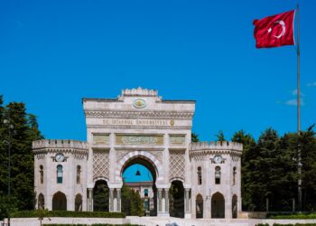 Tarihi İstanbul Üniversitesi ana kapısı önünde dalgalanan büyük Türk bayrağı.
