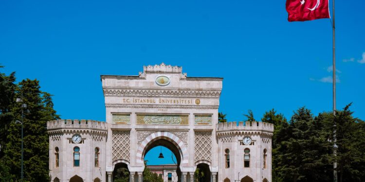 Tarihi İstanbul Üniversitesi ana kapısı önünde dalgalanan büyük Türk bayrağı.