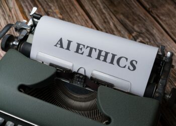 Üzerinde AI Ethics yazan bir kağıt takılı eski tip yeşil daktilo.