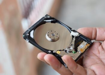 Elde tutulan açık bir sabit disk ve mekanik bileşenleri.